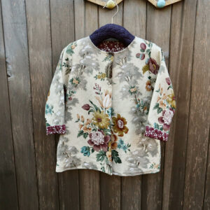 Vintage-inspired toddler jacket handmade from Sanderson 1950s fabric on wooden hanger.