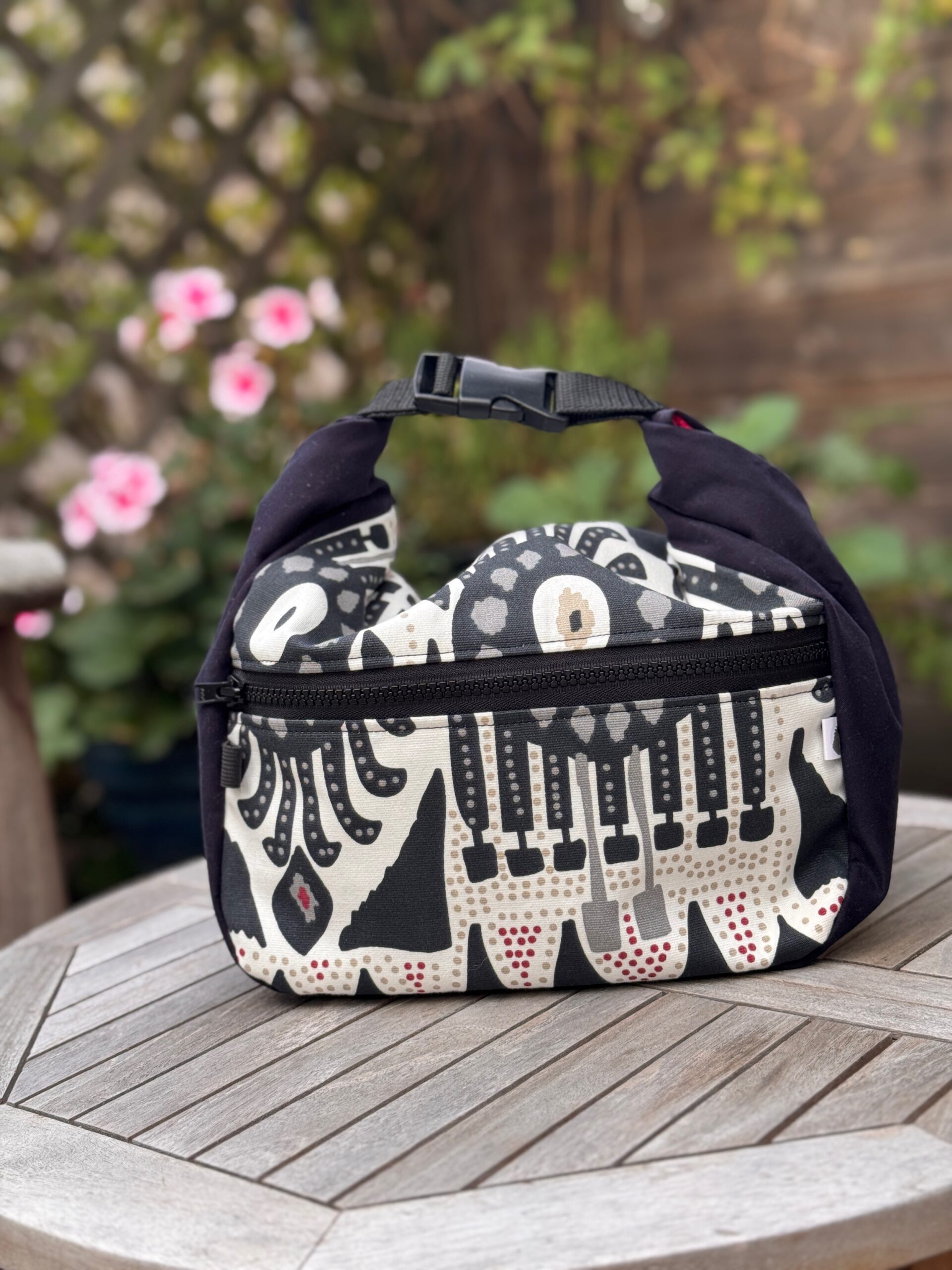 Unique chalk bucket with wide base, open top, fleece lining, velcro fastening and zip pocket. Made from repurposed bold black and white cotton fabric