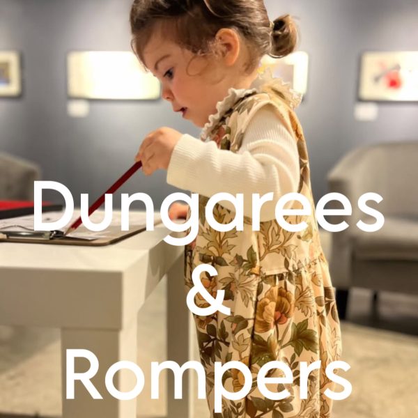 Picture of a toddler girl wearing a romper in vintage floral fabric with the category title Dungarees and rompers