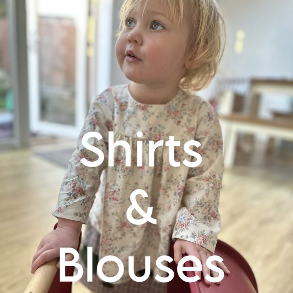 a blonde toddler girl wearing a traditionally styled floral blouse with the caption 'shirts and blouses'